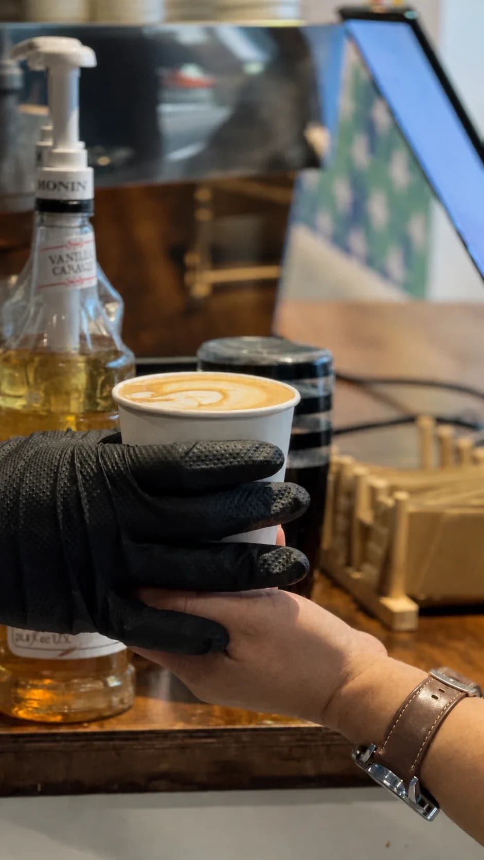 A latte being handed to a guest at a RoastAroma event café